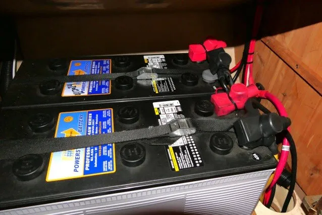 Slide: The Image of Battery setup in a 2001 Hunter 420, featuring dual power cells with red and black cables. - 79