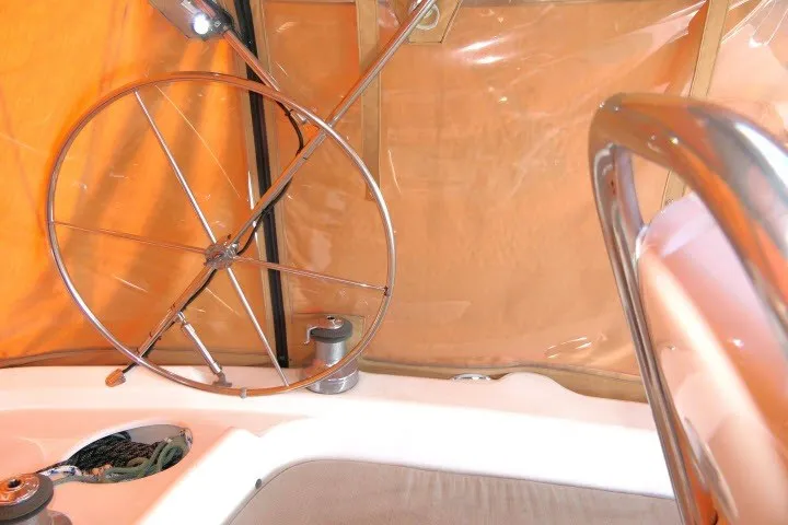 Slide: The Image of Steering wheel of a 2001 Hunter 420 sailboat with orange canopy background. - 45