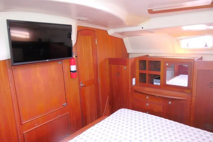 Slide: The Image of Interior of 2001 Hunter 420 yacht with wood paneling and mounted TV. - 31