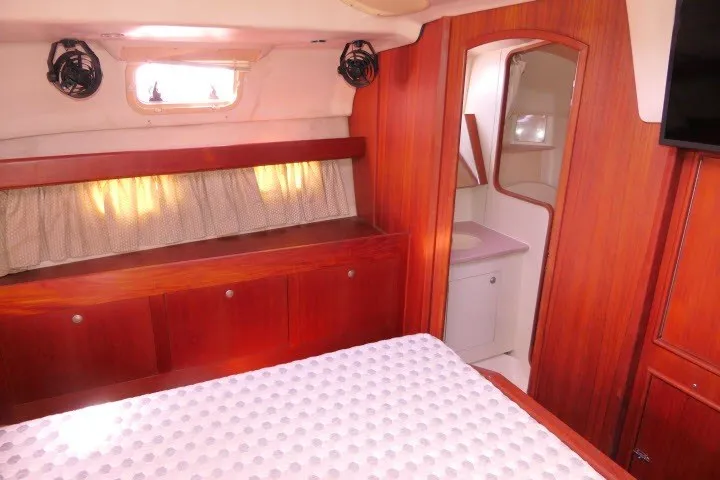 Slide: The Image of Interior of 2001 Hunter 420 yacht cabin with wood paneling and cozy bed. - 29