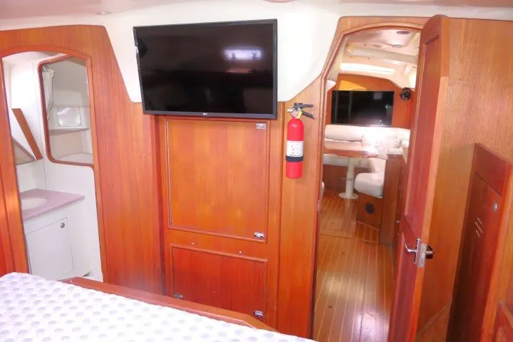 Slide: The Image of Interior of 2001 Hunter 420 yacht with wood paneling, TV, and cozy seating area. - 30