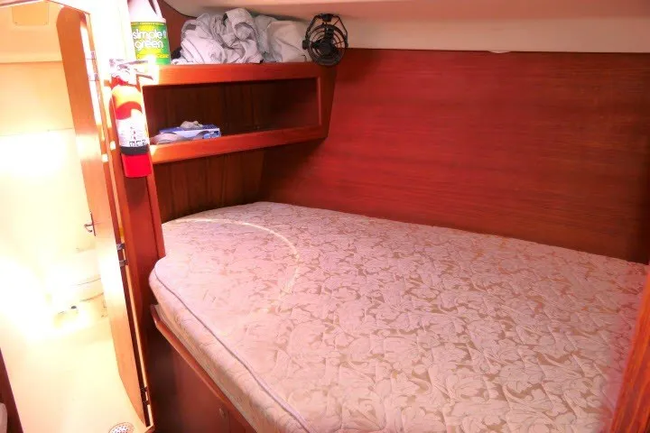 Slide: The Image of Cozy cabin interior of 2001 Hunter 420 sailboat with bed and storage shelves. - 18