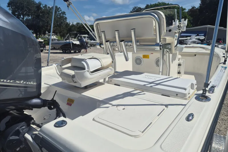 Slide: The Image of 2017 Key West 176 Bay Reef boat interior with seating and motor, parked outdoors. - 6