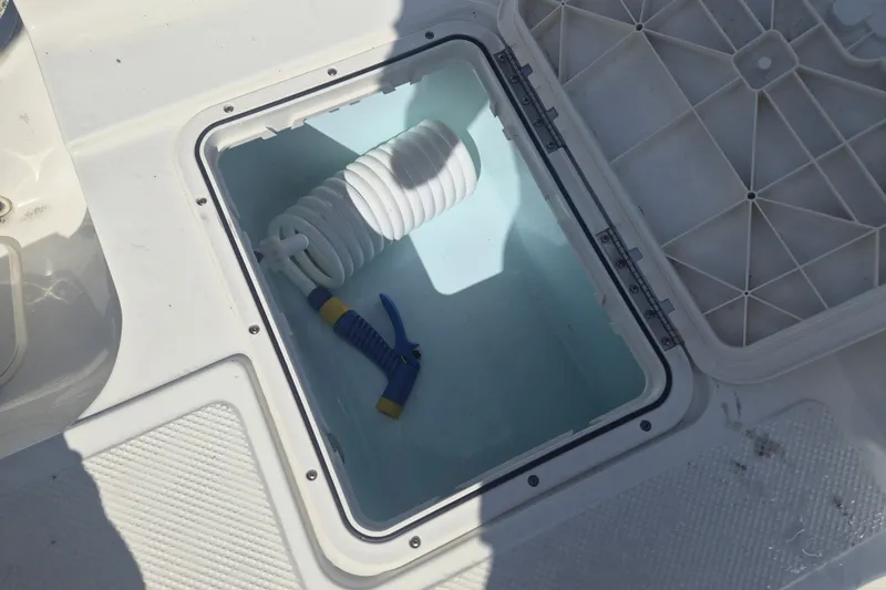 Slide: The Image of Storage compartment on a 2017 Key West 176 Bay Reef boat with coiled hose and nozzle. - 8