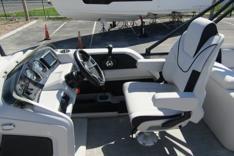 Slide: The Image of 2026 Tahoe Pontoon LTZ Quad Lounger Shift 23 cockpit with steering wheel and captain's chair. - 16