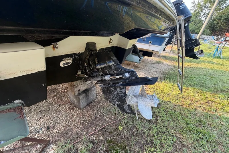 Slide: The Image of 2020 Crownline 264 CR boat stern view with propeller and ladder on grassy area. - 6