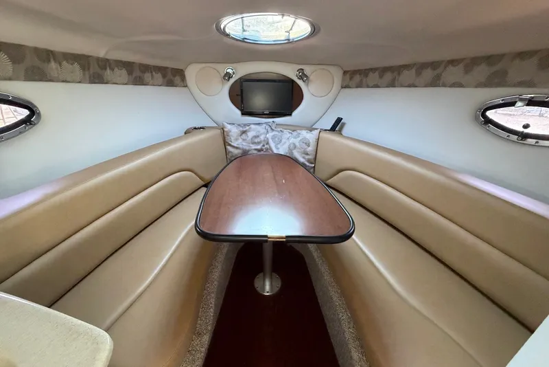 Slide: The Image of Interior of 2020 Crownline 264 CR boat with beige seating and wooden table. - 16