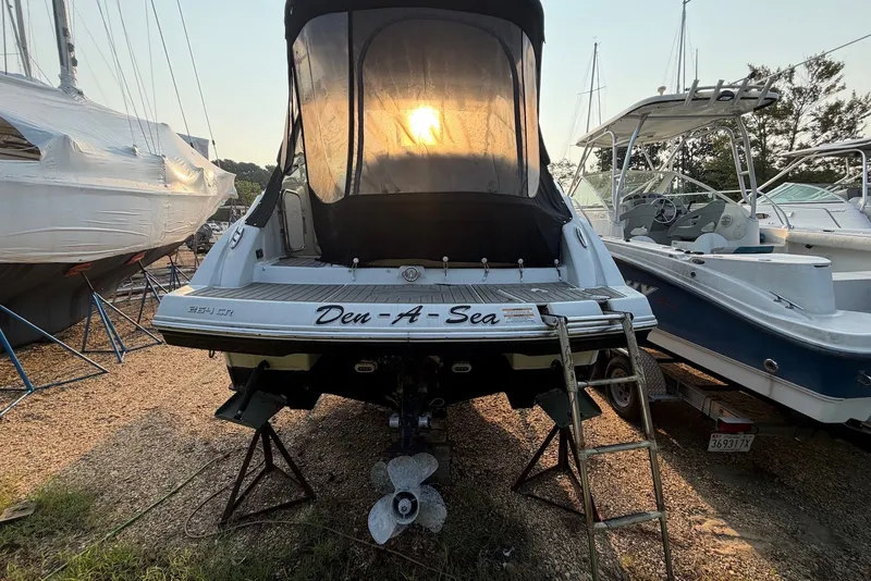 Slide: The Image of 2020 Crownline 264 CR boat on stands, rear view with sunset backdrop. - 5