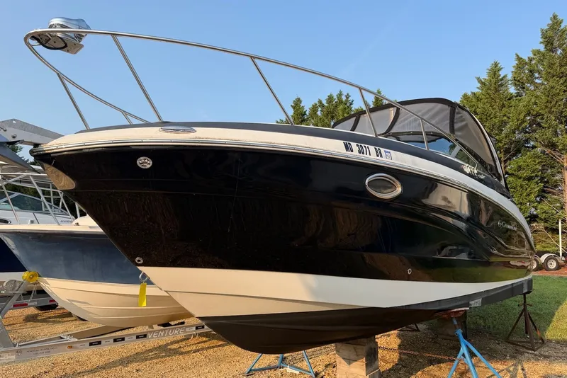 Slide: The Image of 2020 Crownline 264 CR boat on trailer, black and white hull, parked outdoors. - 1