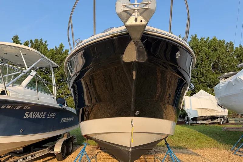 Slide: The Image of 2020 Crownline 264 CR boat on stands, surrounded by other boats, sunny day. - 2