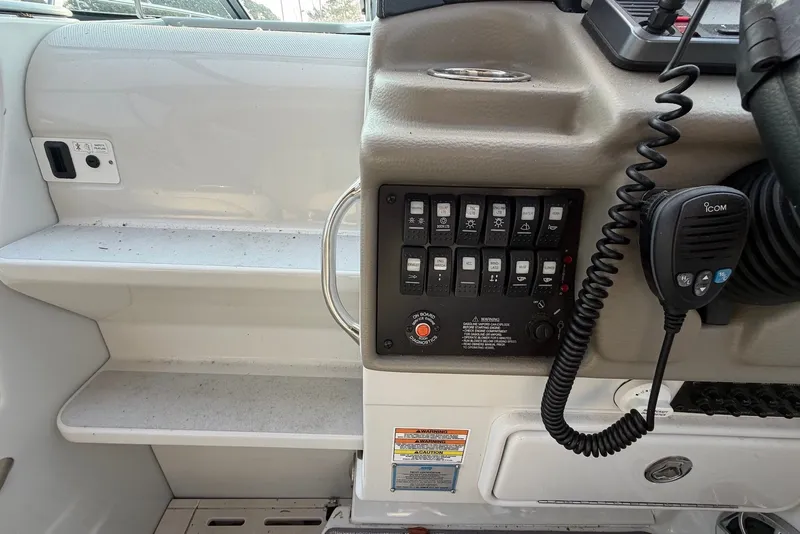 Slide: The Image of Control panel of a 2020 Crownline 264 CR boat with switches and a radio handset. - 10