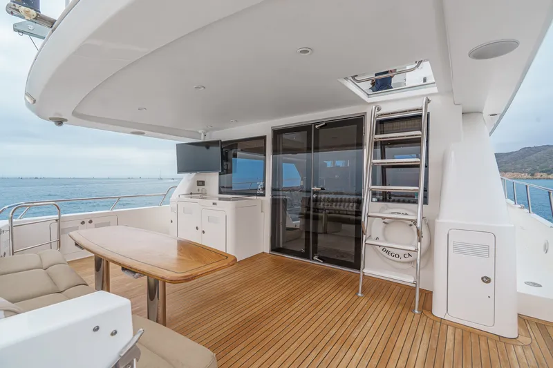 Slide: The Image of The 2005 West Bay 80 CPMY features a sleek aft deck with wood flooring, table, and seating area. - 35