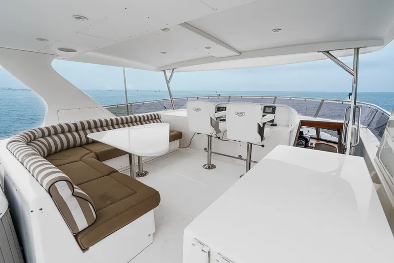 Slide: The Image of The image shows the spacious deck of a 2005 West Bay 80 CPMY with seating area and helm. - 21