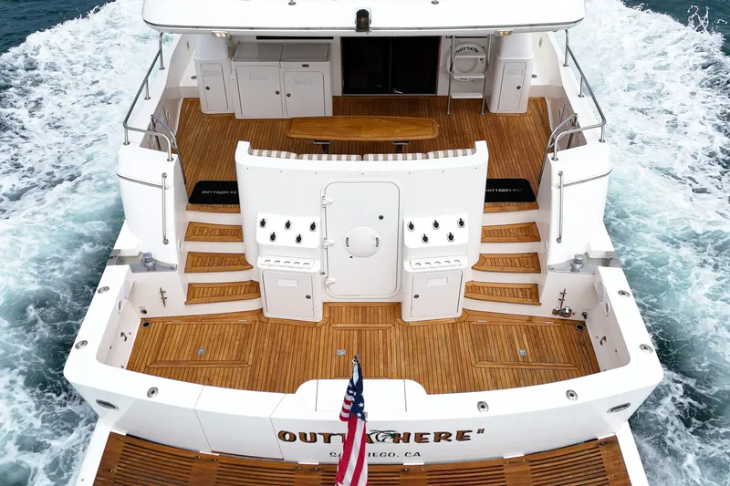 Slide: The Image of The 2005 West Bay 80 CPMY features a spacious aft deck with wood paneling and an American flag. - 27