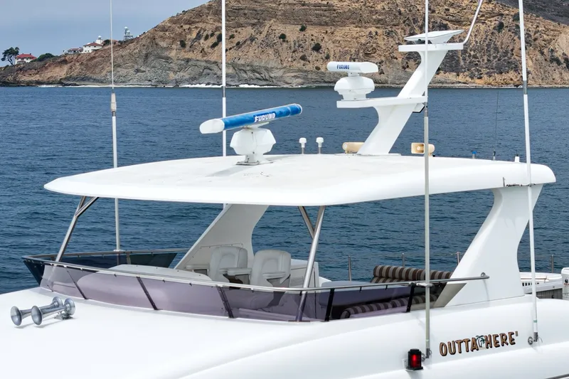 Slide: The Image of A luxurious yacht with a spacious upper deck, situated on the water near a rocky coastline. - 12