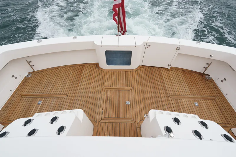 Slide: The Image of The image shows the teak deck of a 2005 West Bay 80 CPMY with a flag at the stern. - 30