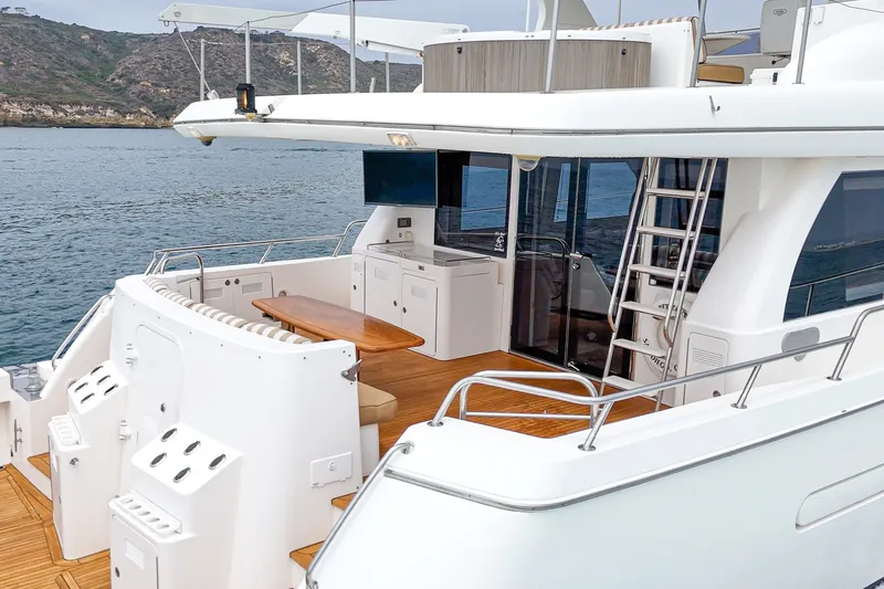 Slide: The Image of The 2005 West Bay 80 CPMY features a sleek aft deck with wooden flooring and seating area. - 34