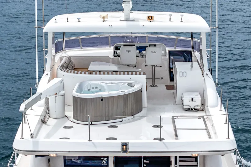 Slide: The Image of The 2005 West Bay 80 CPMY features a spacious deck with a hot tub and seating area. - 15