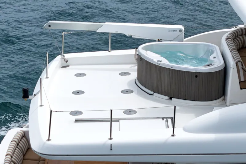 Slide: The Image of The image shows the deck of a 2005 West Bay 80 CPMY with a hot tub. - 19