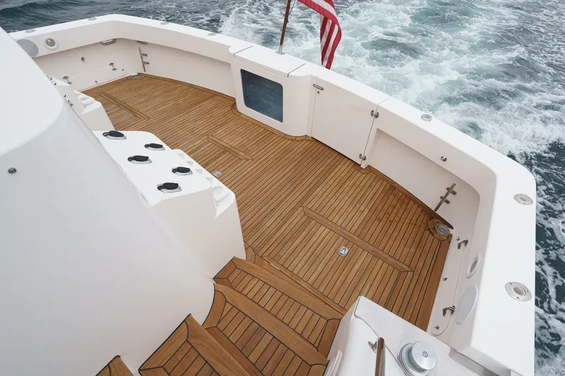 Slide: The Image of The image shows the teak deck of a 2005 West Bay 80 CPMY with an American flag. - 32