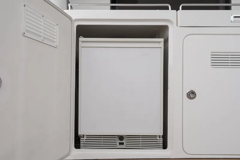 Slide: The Image of A built-in refrigerator in a white cabinet on a boat. - 37