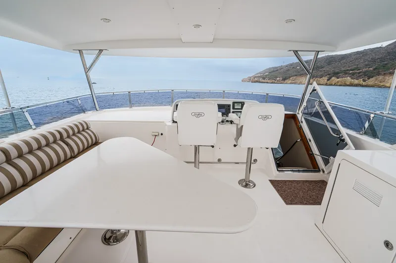 Slide: The Image of The image shows the helm of a 2005 West Bay 80 CPMY with two white seats and a table. - 22
