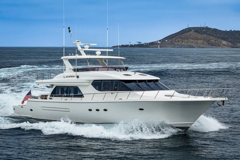 Slide: The Image of A sleek white yacht cruising swiftly on the sea, with an island in the background. - 6