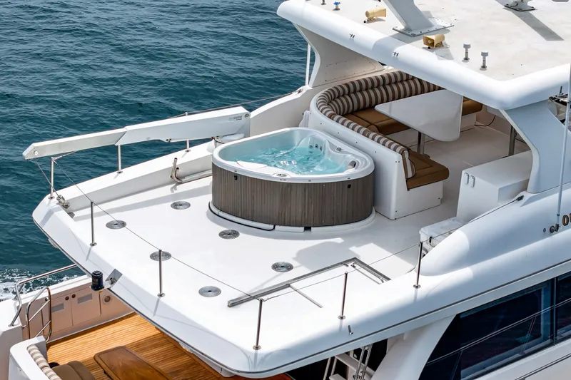 Slide: The Image of Luxurious yacht with a hot tub on the upper deck, surrounded by seating, on calm water. - 16