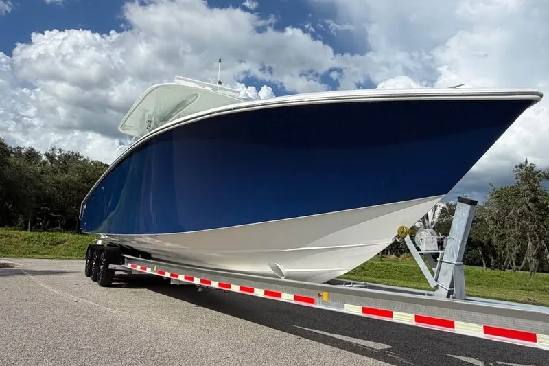 Slide: The Image of 2012 Bahama 37 boat on trailer under cloudy sky. - 5