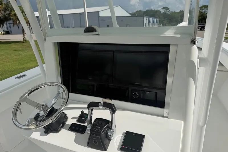 Slide: The Image of Center console of a 2012 Bahama 37 boat with steering wheel and controls. - 18