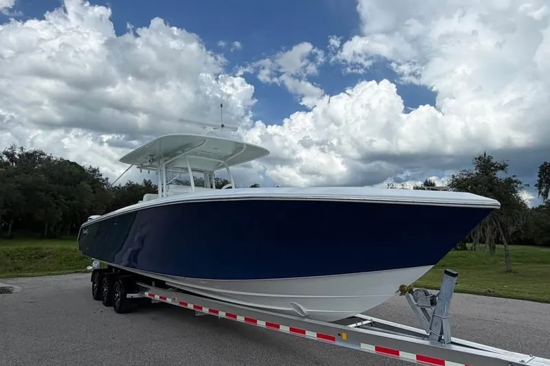 Slide: The Image of 2012 Bahama 37 boat on trailer under cloudy sky, parked on road. - 3