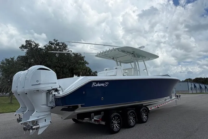 Slide: The Image of 2012 Bahama 37 boat with dual Yamaha engines on a trailer under cloudy skies. - 4
