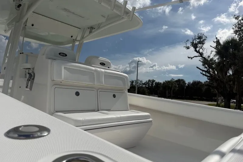 Slide: The Image of 2012 Bahama 37 boat interior with white seating under a clear blue sky. - 15