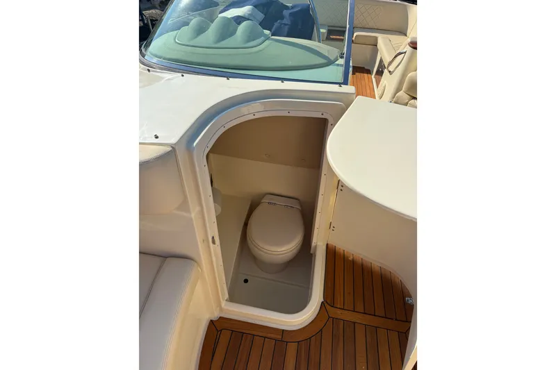 Slide: The Image of 2018 Chris-Craft Launch 30 boat interior with compact marine toilet and teak flooring. - 8