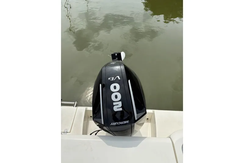 Slide: The Image of 2024 Cobia 220 Dual Console with Mercury 200 V6 outboard engine on water. - 9