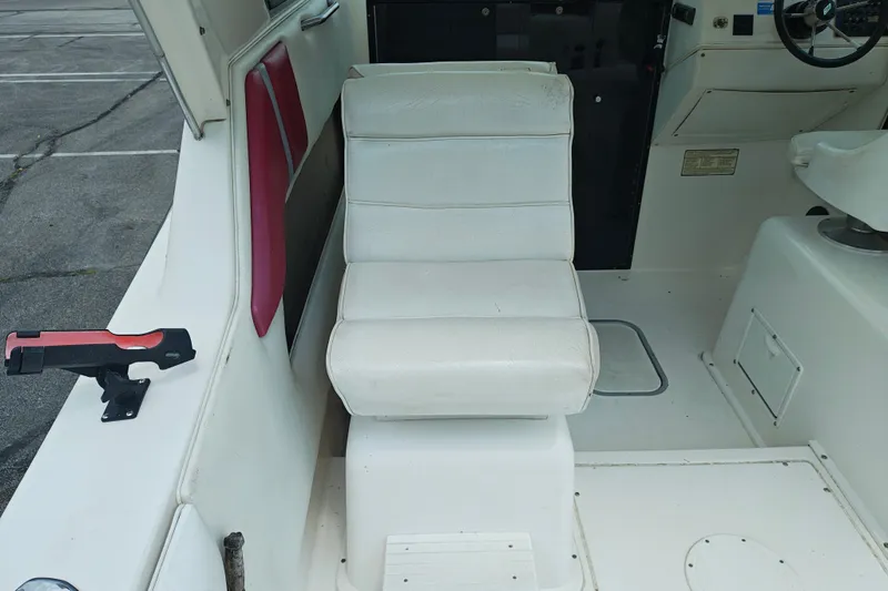 Slide: The Image of White interior seating of a 1996 SportsCraft 232HT boat, featuring a cushioned chair. - 18