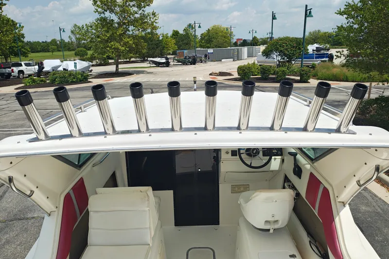 Slide: The Image of 1996 SportsCraft 232HT boat interior with rod holders, parked outdoors. - 10