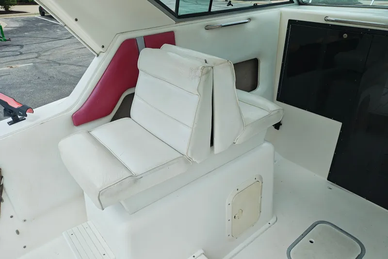 Slide: The Image of White interior seating of a 1996 SportsCraft 232HT boat with red accents. - 17