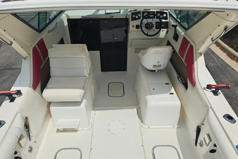 Slide: The Image of Interior of a 1996 SportsCraft 232HT boat, featuring white seating and control panel. - 11