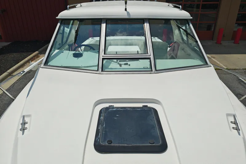 Slide: The Image of White 1996 SportsCraft 232HT boat with windshield and hatch, parked outdoors. - 34