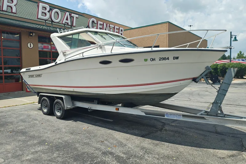 Slide: The Image of 1996 SportsCraft 232HT boat on trailer outside a boat center. - 2