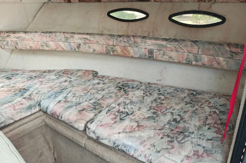 Slide: The Image of Interior cabin of a 1996 SportsCraft 232HT boat with patterned upholstery and small windows. - 30