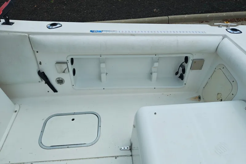 Slide: The Image of Interior view of a 1996 SportsCraft 232HT boat, featuring storage compartments and seating. - 14