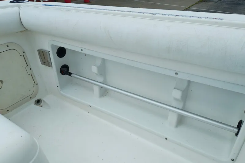 Slide: The Image of Interior view of a 1996 SportsCraft 232HT boat, showcasing storage compartment and rod holder. - 16