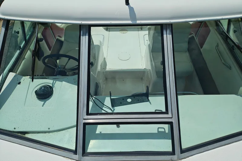 Slide: The Image of Interior view of a 1996 SportsCraft 232HT boat, showing steering wheel and seating. - 36