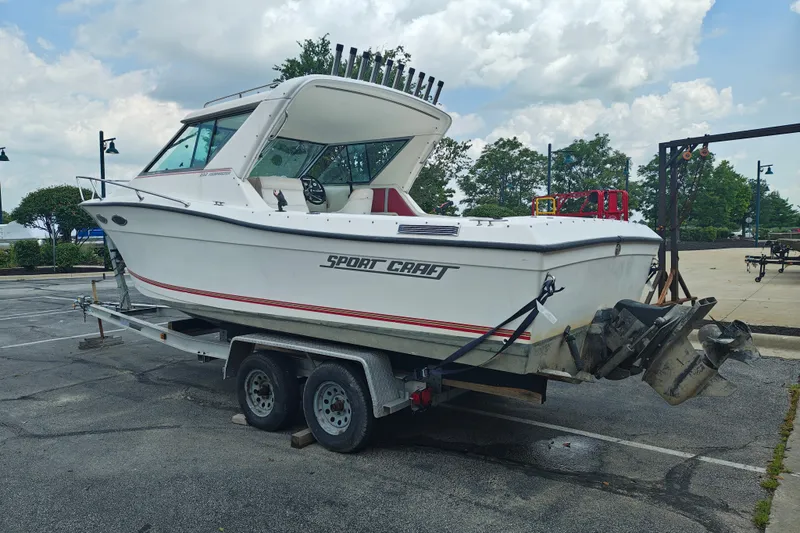 Slide: The Image of 1996 SportsCraft 232HT boat on trailer in parking lot, cloudy sky background. - 6