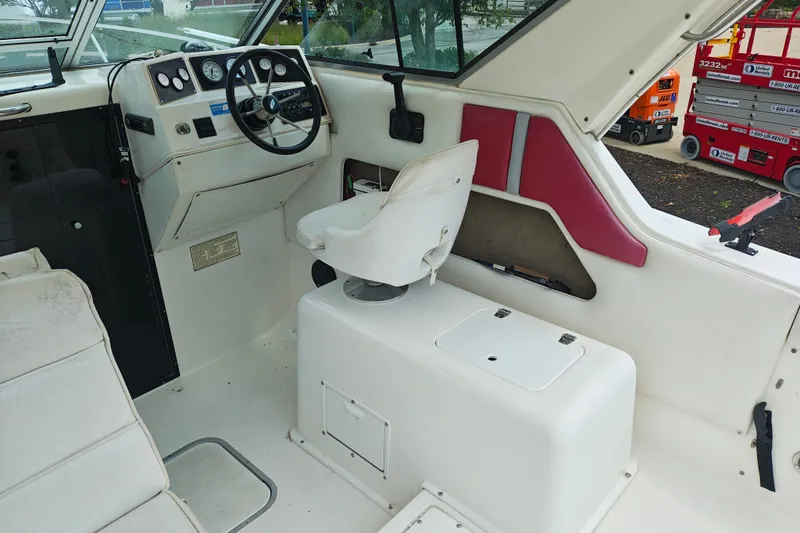 Slide: The Image of Interior of a 1996 SportsCraft 232HT boat, featuring steering wheel and seating. - 19