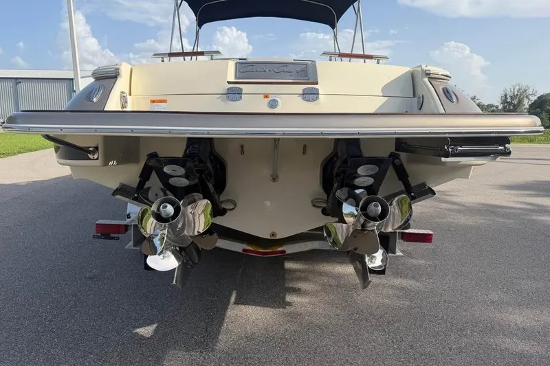 Slide: The Image of 2018 Chris-Craft Corsair 30 boat rear view with dual propellers and sleek design. - 20