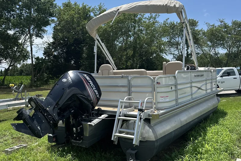 Slide: The Image of 2018 Berkshire 22RFC CTS pontoon boat with Mercury outboard motor, parked on grass. - 5