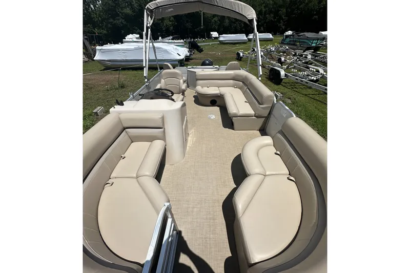 Slide: The Image of 2018 Berkshire 22RFC CTS pontoon boat with beige seating and canopy, parked outdoors. - 11
